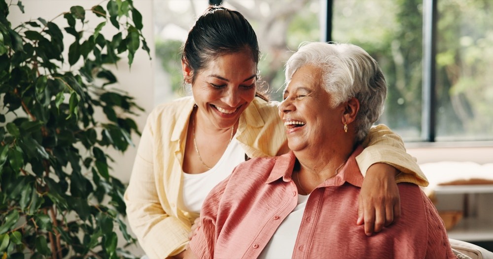 An adult daughter laughing with her mother